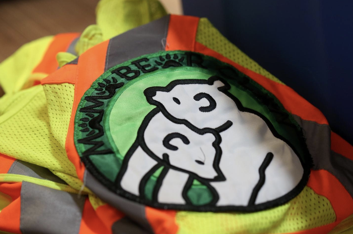 Fluorescent vest with a mother bear and cub patch. 