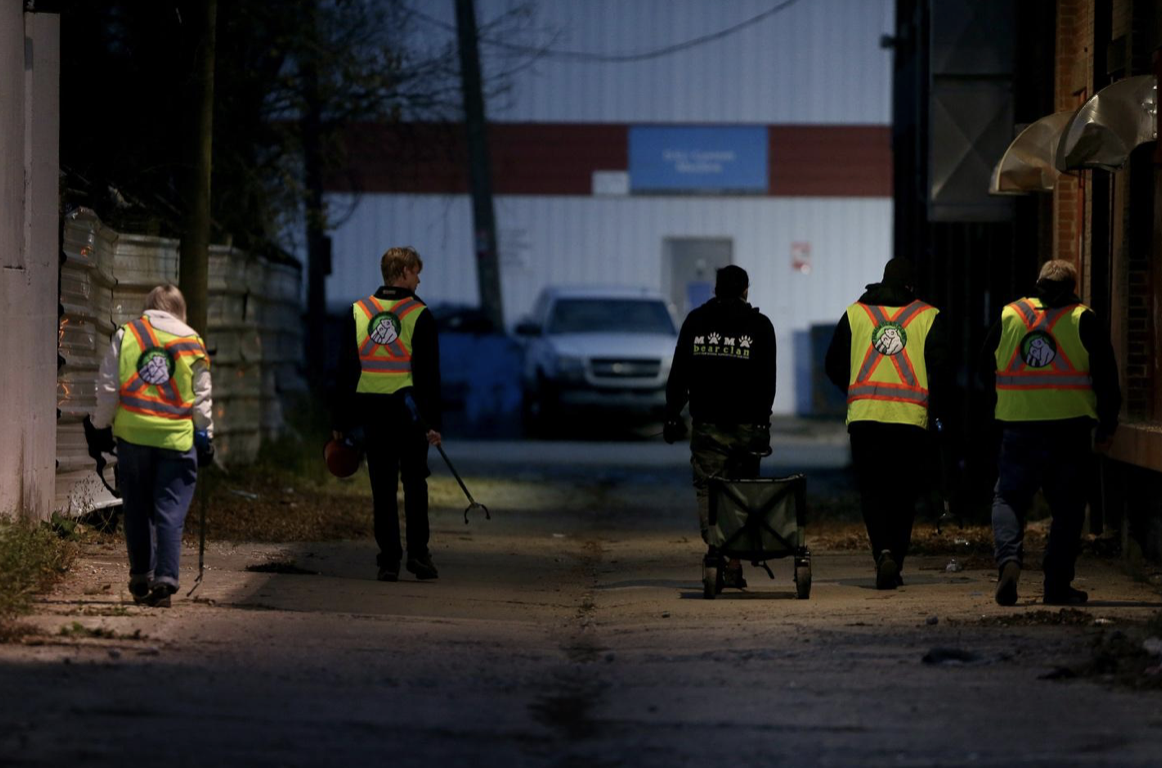 Volunteers walk an alley in Winnipeg’s North Point Douglas Neighbourhood. 