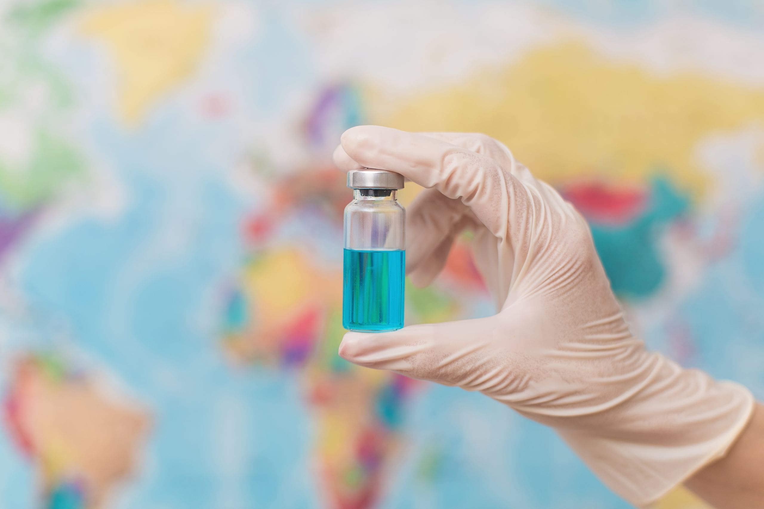 Doctor holds an ampoule with a vaccine on the back.