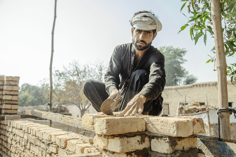 A man rebuilds his home following the August 2022 floods in Pakistan. 