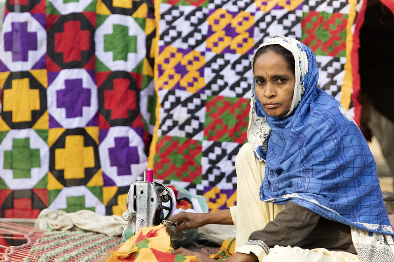 A local woman sewing in the south eastern city of Daddu, Pakistan after the 2022 floods.