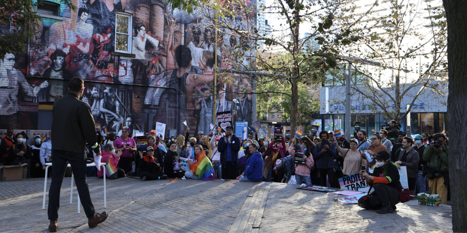 Curran Stikus, director of advocacy for The 519, speaks to an assembled crowd of pro-LGBTQ protestors in Barbara Hall Park in Toronto, Ont., before the group marched to Queens Park.