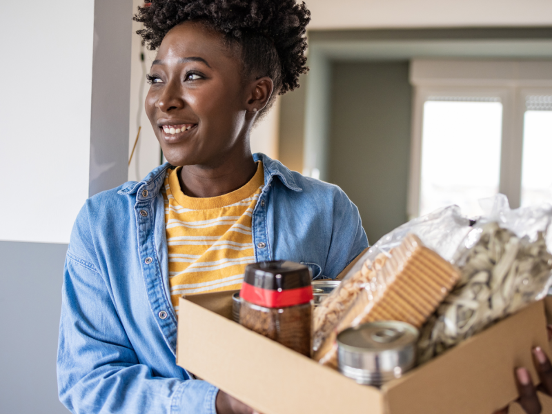 Woman holding a box of products for charity.