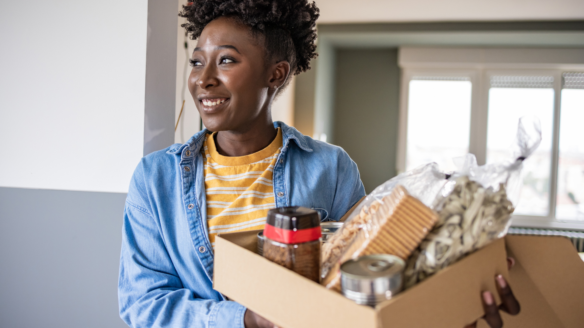 Woman holding a box of products for charity.