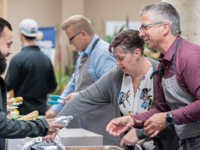 Chad Friesen, right, of Friesens Corporation, serves up a Thanksgiving lunch during the company’s Employee Owner Days in October of 2023.