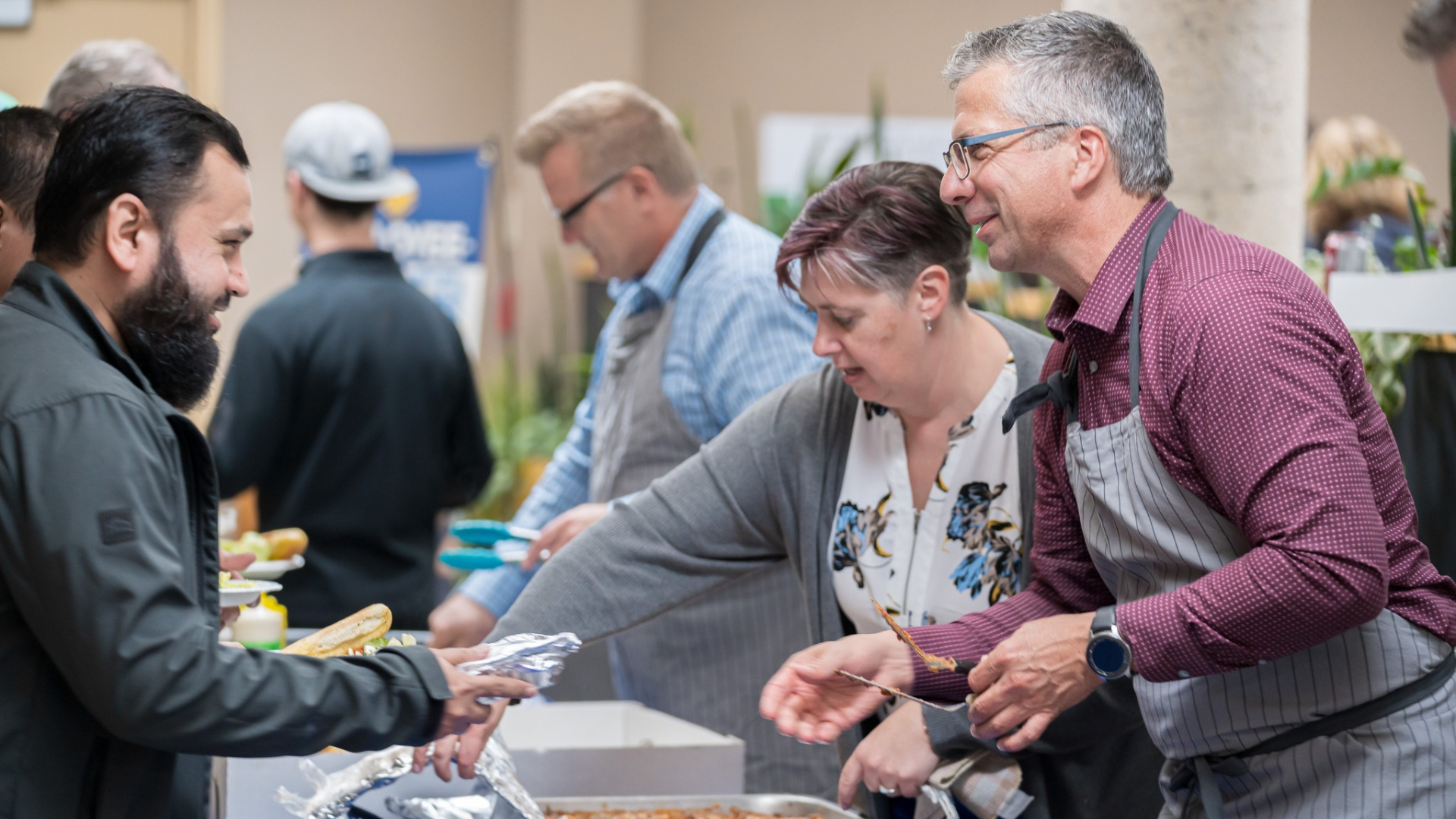 Chad Friesen, right, of Friesens Corporation, serves up a Thanksgiving lunch during the company’s Employee Owner Days in October of 2023.