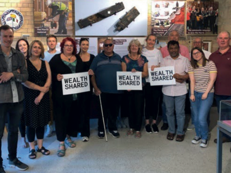 David Clarke (left) stands with the facilitator and participants of Wealth Shared, a philanthropy experiment where 12 strangers collectively decided how to donate £100,000 of Clarke’s wealth.