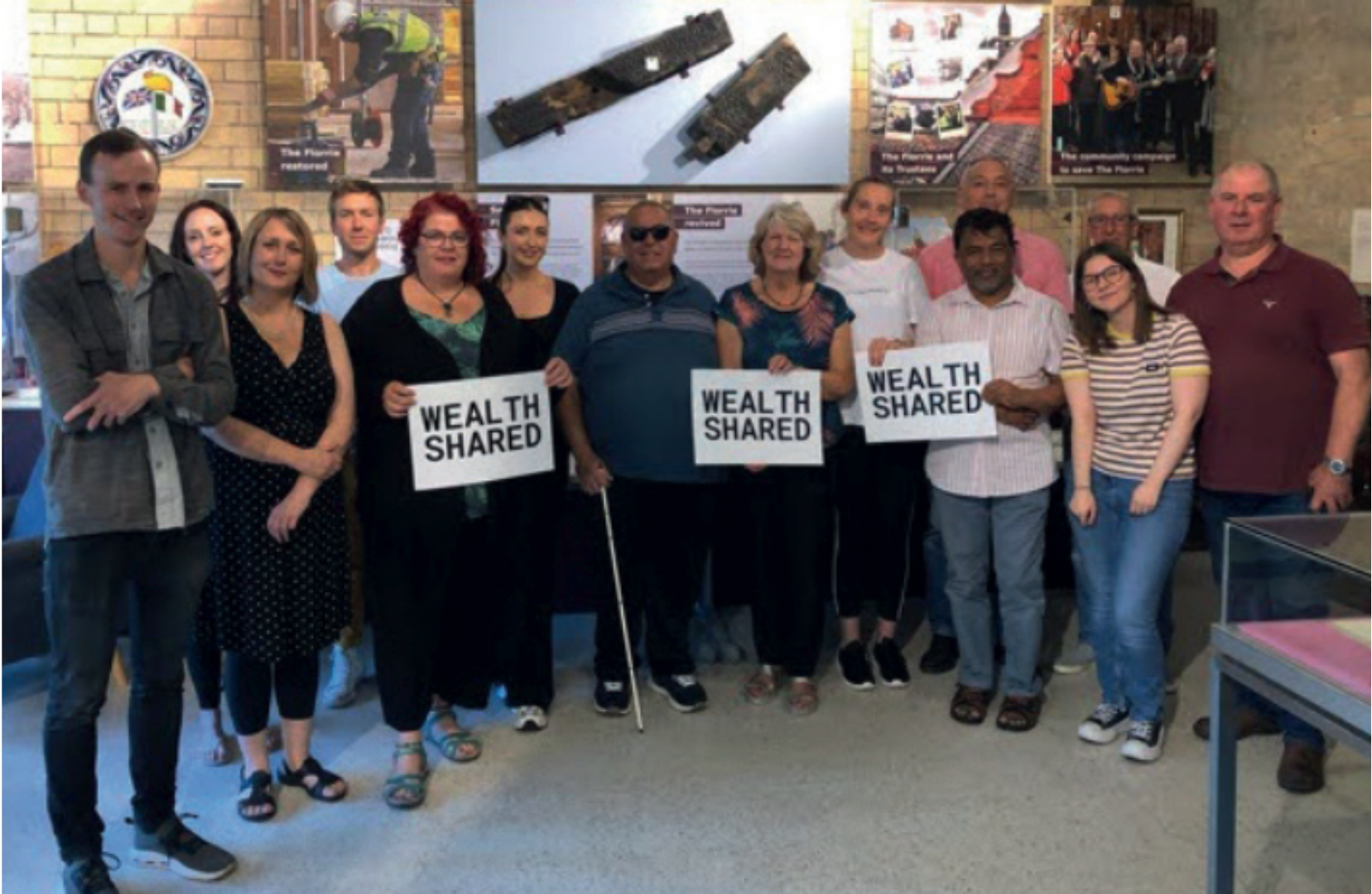 David Clarke (left) stands with the facilitator and participants of Wealth Shared, a philanthropy experiment where 12 strangers collectively decided how to donate £100,000 of Clarke’s wealth.