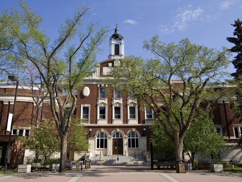 A four storey redbrick administrative building of late Victorian style on a sunny spring day.