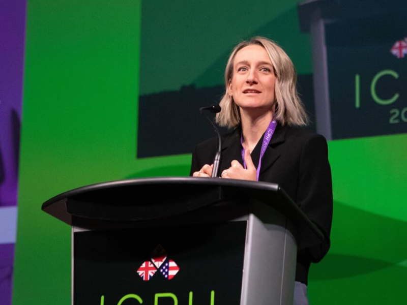 Dr. Joss Reimer stands at a podium on a green stage at a conference in Halifax in October of 2024. The President of the Canadian Medical Association says they felt they had no choice but to file a lawsuit to protect trans youth.