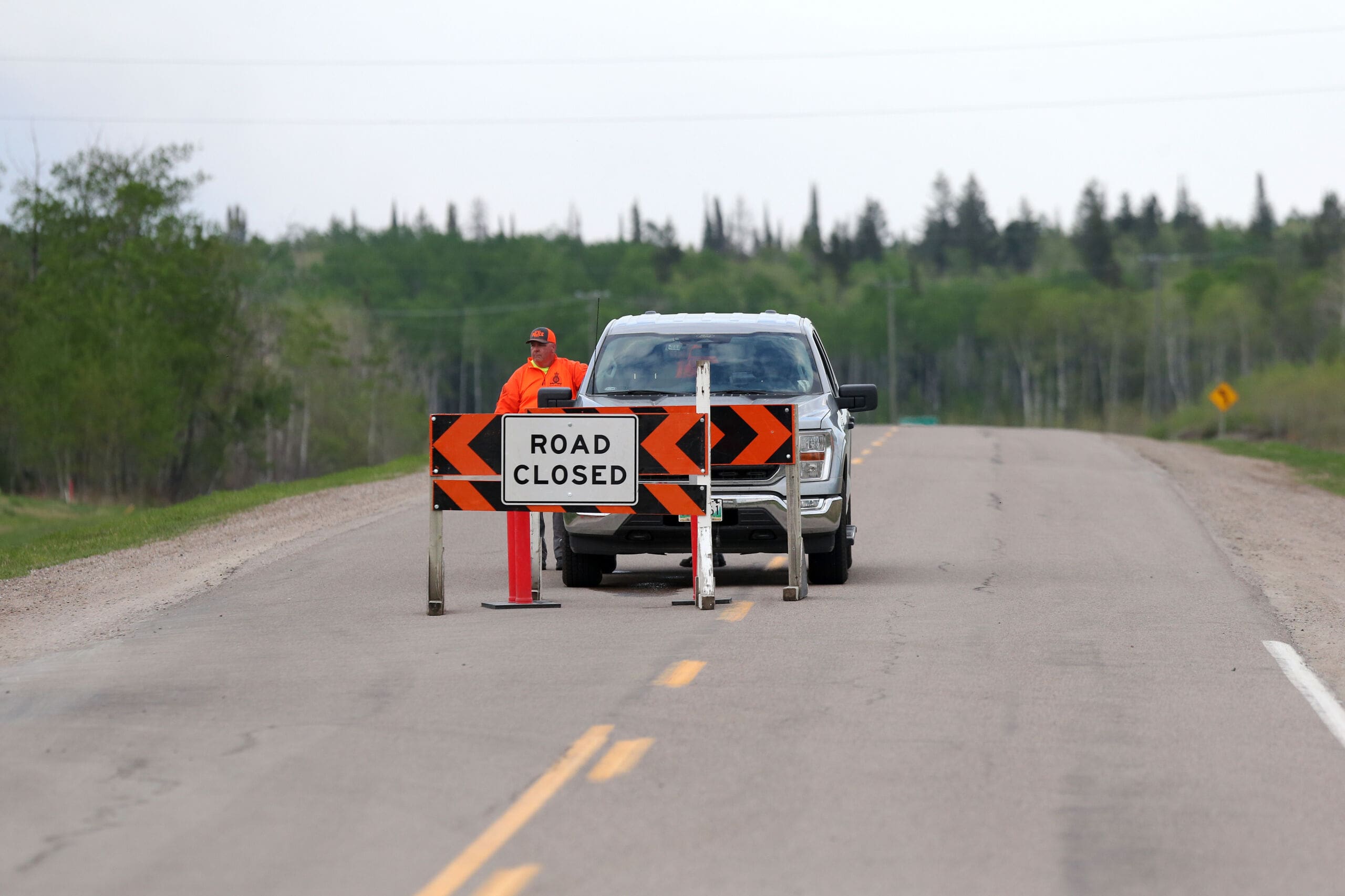Members of the Royal Canadian Mounted Police enforce a mandatory evacuation order north of Lac du Bonnet, Man. on May 15, 2025. (Shannon VanRaes/The Globe and Mail)