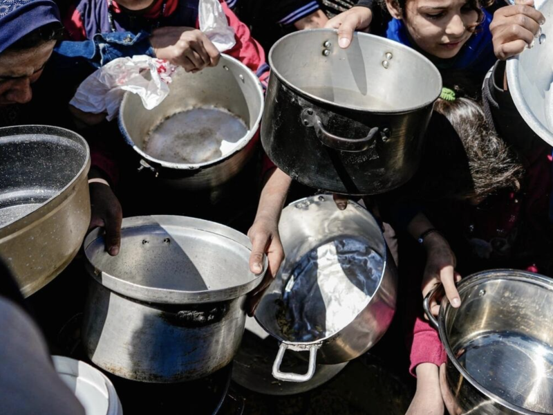 Starving children hold empty pots in Gaza.
